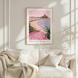 a framed poster of Copacabana Beach hanging on a wall above a white couch with a blanket draped over it.