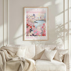 a framed poster of a cityscape with a floral design, hanging on a wall above a white couch with a blanket draped over it.