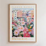 The image is a framed poster depicting a vibrant and colorful flower market in Rosemary Beach, with a variety of flowers and buildings in the background.