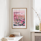 a framed poster of a field of flowers, specifically a field of daisies, hanging on a wall.