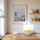 a kitchen scene with a framed poster of a colorful floral design hanging on the wall above a wooden countertop with a bowl of lemons.