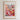 The image is a framed poster depicting a vibrant and colorful street scene with a variety of flowers and plants.