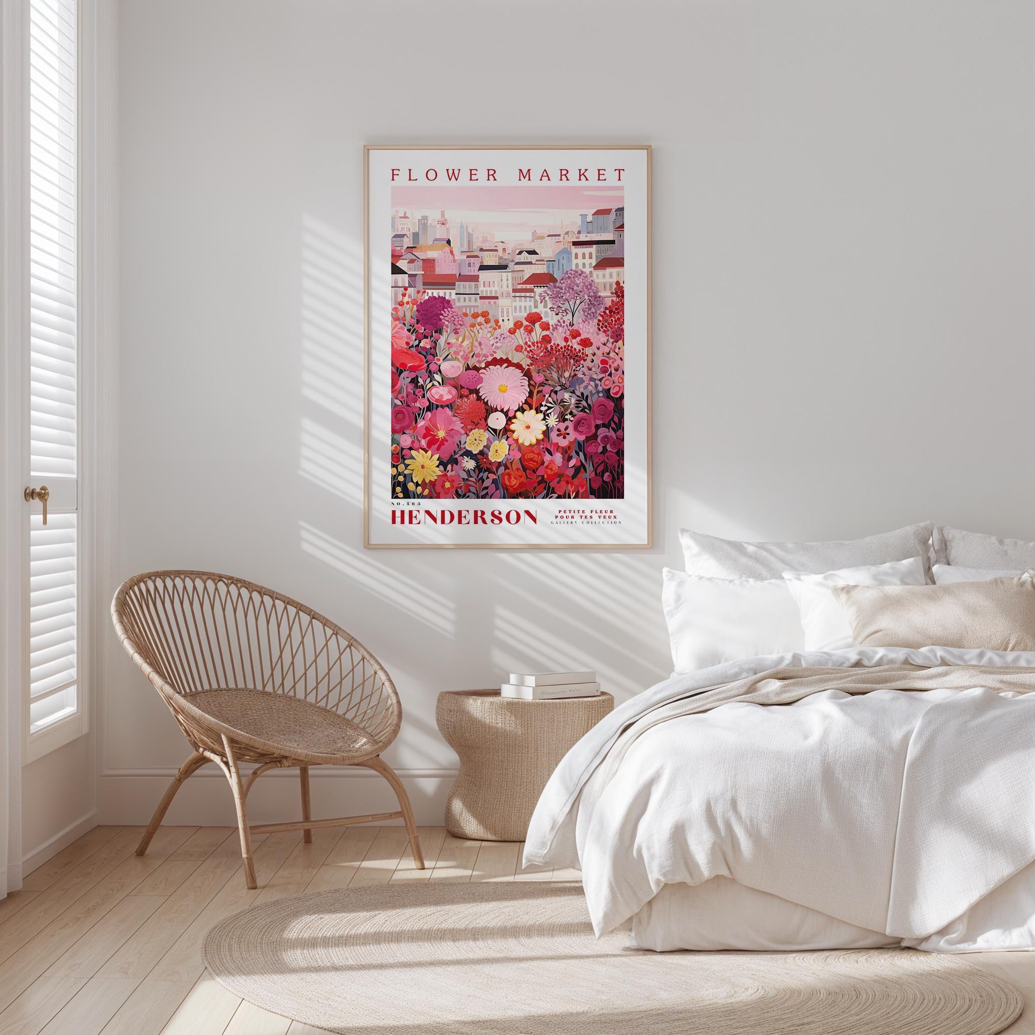 a bedroom with a bed, a wicker chair, and a framed poster of a flower market hanging on the wall.