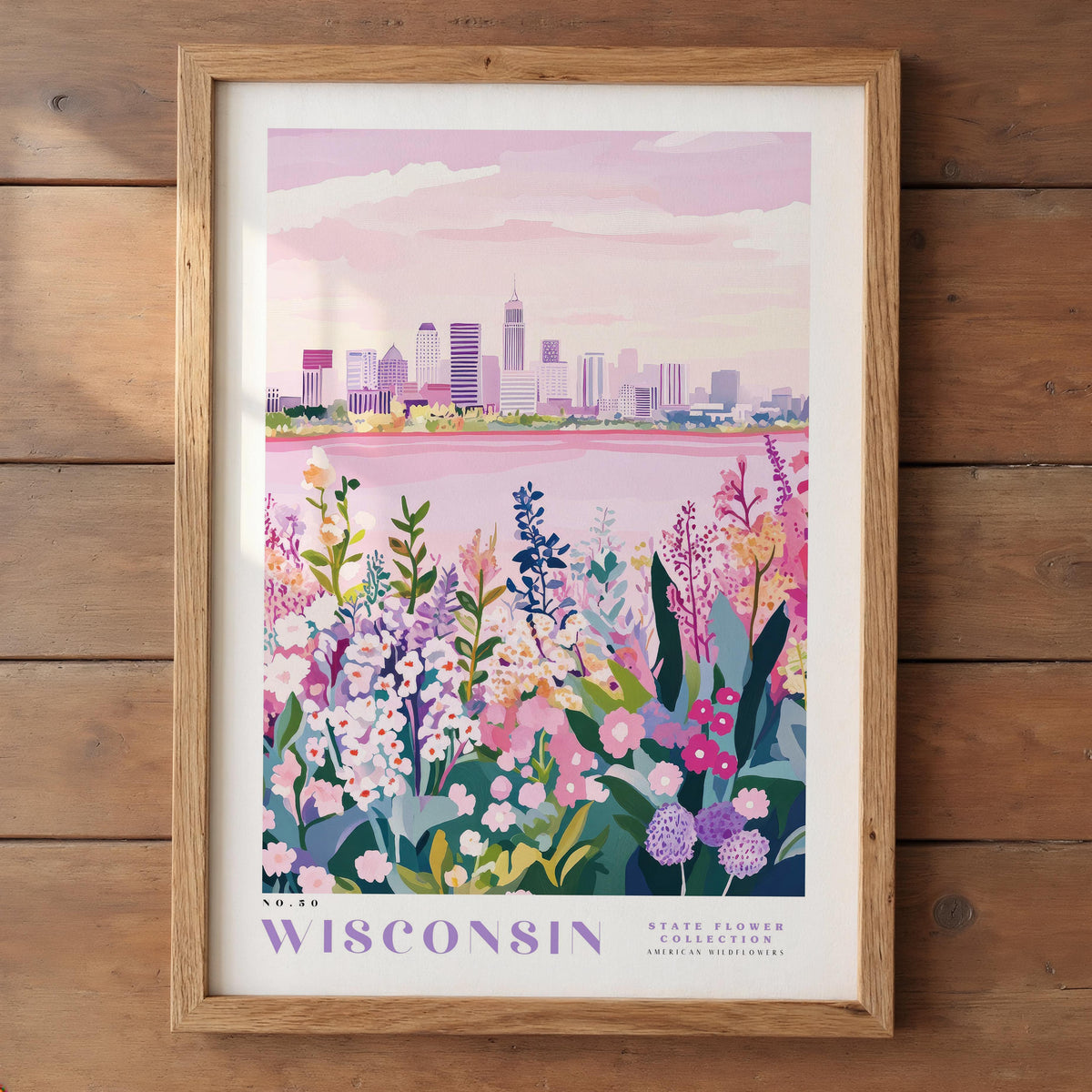A framed poster depicting a cityscape with a field of colorful wildflowers in the foreground, set against a pink and purple sky.