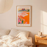 a bedroom with a bed, a nightstand, and a framed poster of a beach scene hanging on the wall.