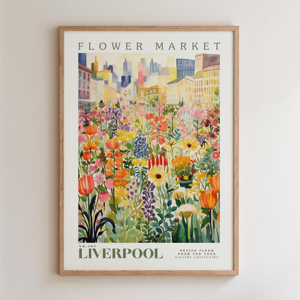 The image is a framed poster depicting a vibrant and colorful flower market in Liverpool, with a variety of flowers and plants arranged in a visually appealing manner.