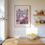 a kitchen counter with a bowl of lemons, a framed poster of Melbourne's flower market, and shelves with various jars and containers.