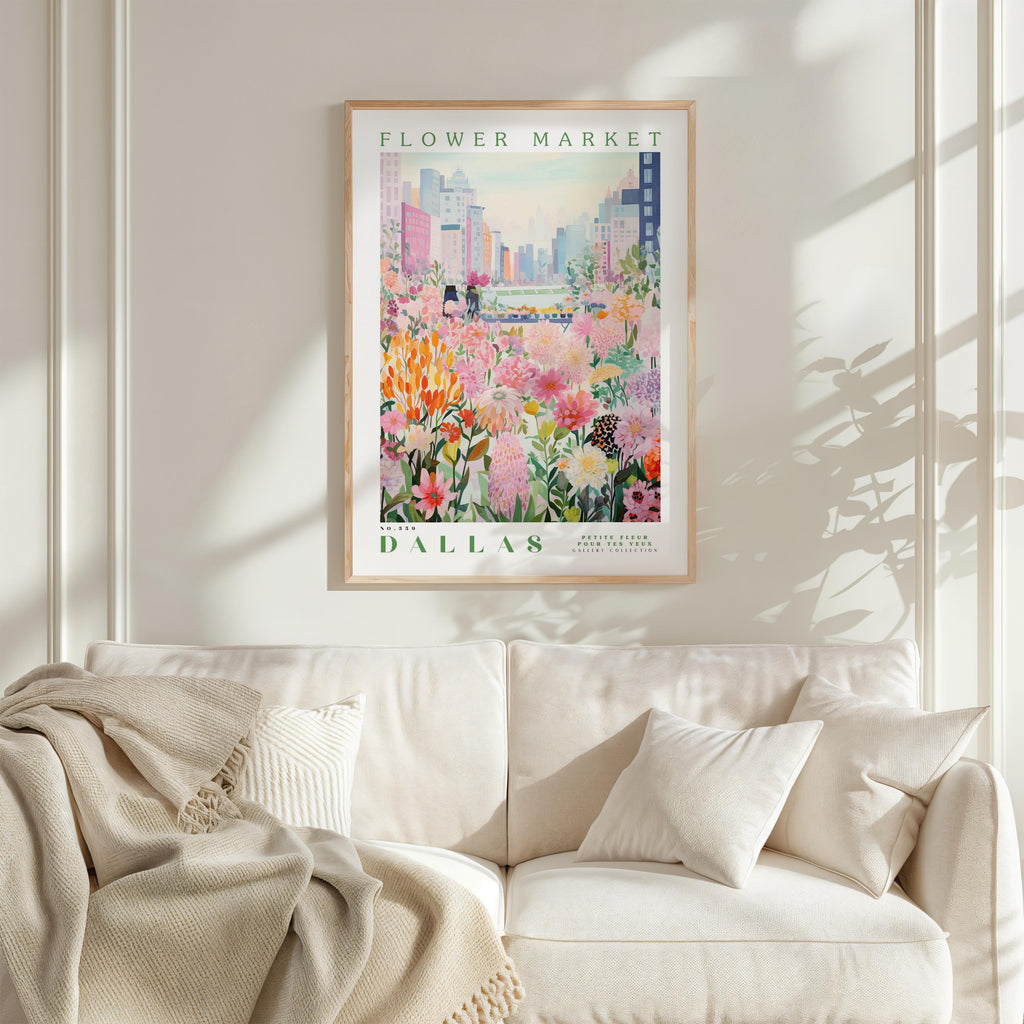 a framed poster of a flower market in Dallas, Texas, hanging on a wall above a white couch.