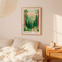 a framed poster of a forest scene hanging on a wall above a bed with striped pillows.