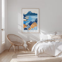 a bedroom with a large poster of a tropical beach scene hanging on the wall above a bed with white bedding.