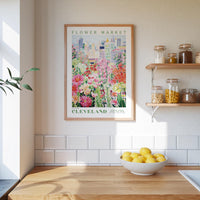 a framed poster of a colorful floral scene hanging on a wall above a kitchen counter with a bowl of lemons on it.