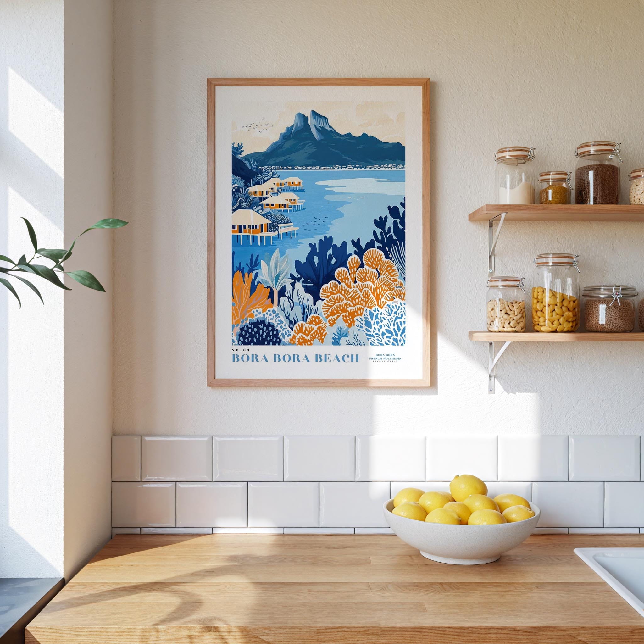 a kitchen scene with a framed poster of a tropical beach landscape hanging on the wall above a wooden countertop with a bowl of lemons.