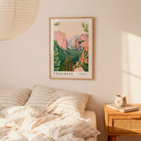 a framed poster of Yosemite National Park hanging on a wall above a bed with striped pillows.