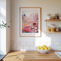 a framed poster of a colorful floral scene hanging on a wall above a wooden countertop with a bowl of lemons.