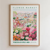 The image is a framed poster depicting a vibrant flower market scene with colorful flowers and buildings in the background.