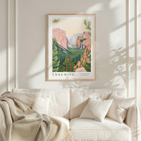 a framed poster of Yosemite National Park hanging on a wall above a white couch with a blanket draped over it.