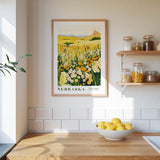 a kitchen scene with a framed print of a field of flowers hanging on the wall, a bowl of lemons on the counter, and shelves displaying various jars and containers.