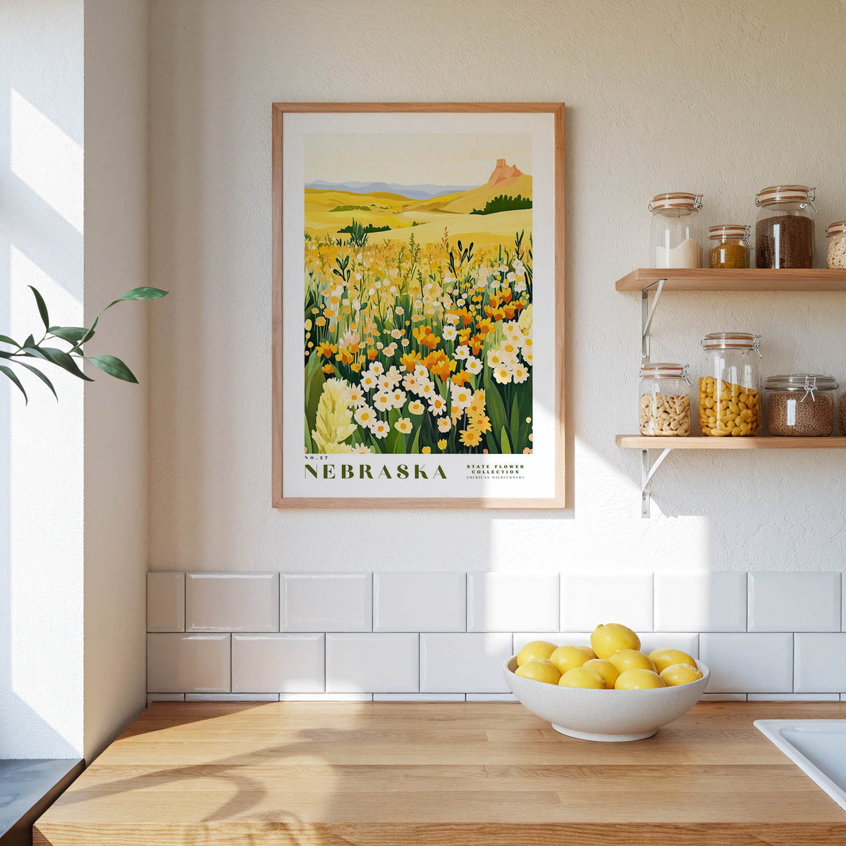 a kitchen scene with a framed print of a field of flowers hanging on the wall, a bowl of lemons on the counter, and shelves displaying various jars and containers.
