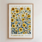 The image is a framed poster of a field of yellow sunflowers, with the text "FLOWER MARKET" and "NASHVILLE" printed on it.