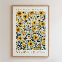 The image is a framed poster of a field of yellow sunflowers, with the text "FLOWER MARKET" and "NASHVILLE" printed on it.