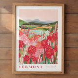 The image is a framed poster depicting a scenic landscape of a mountainous area with a river and a field of colorful flowers.
