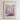 The image is a framed poster depicting a cityscape with colorful flowers and buildings, titled "Flower Market Rosemary Beach" and featuring the text "N°56" and "PITÉ FLEUR GALLERY COLLECTION".