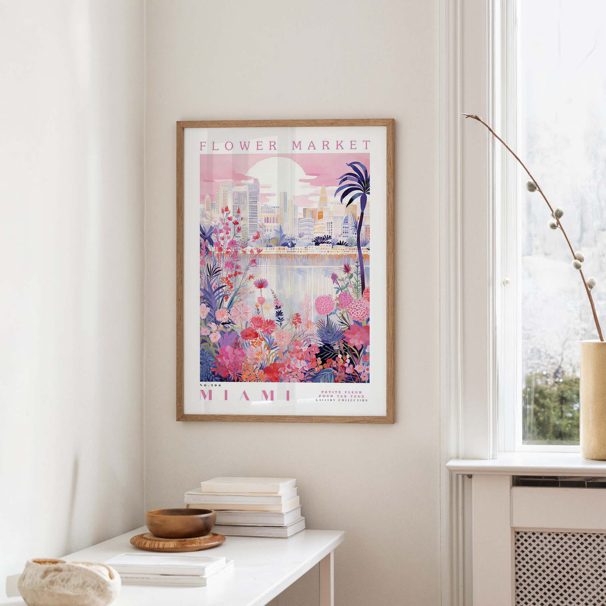 a framed poster of a colorful, floral-themed cityscape hanging on a wall in a room.