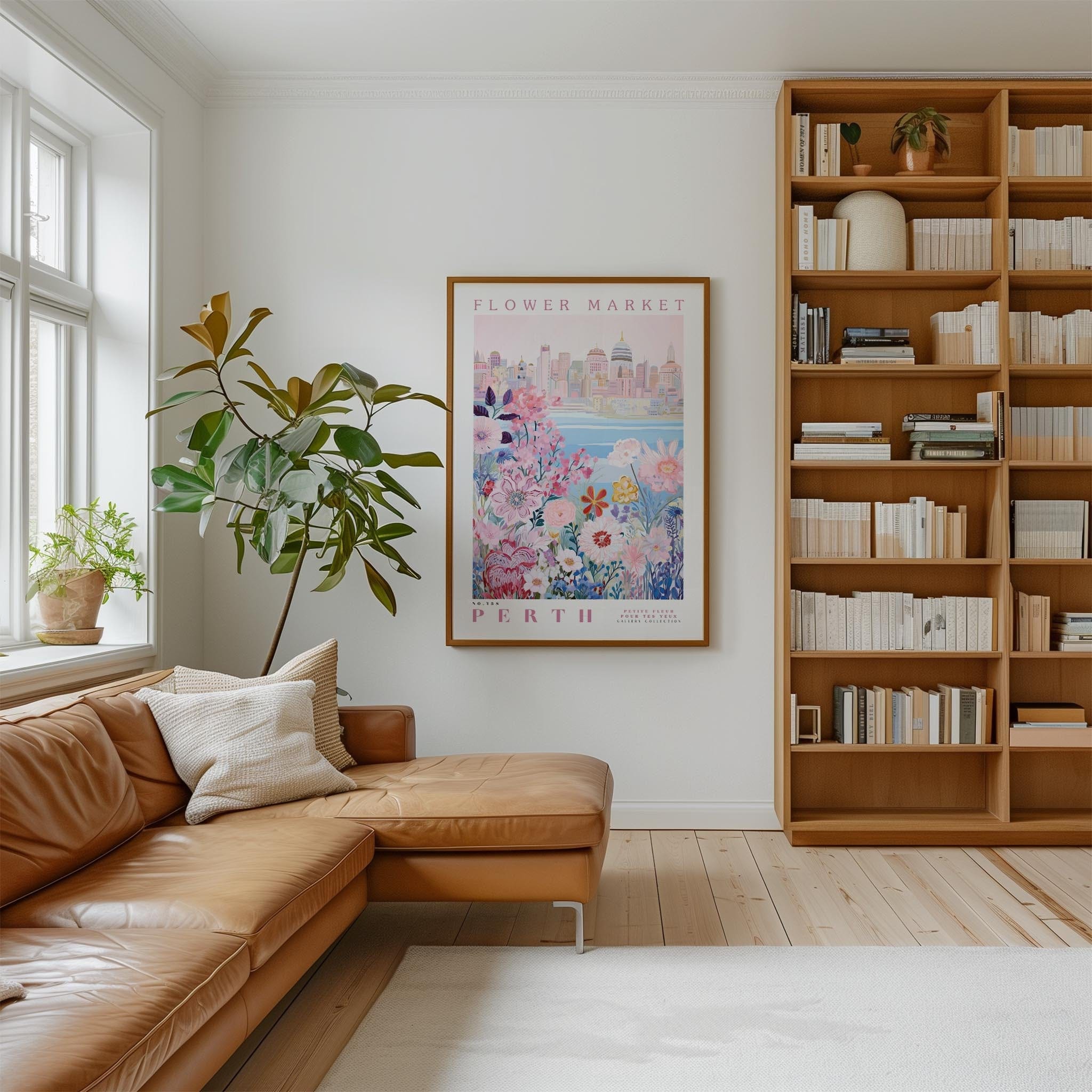 a cozy living room with a large window, a comfortable leather couch, a bookshelf filled with books, and a framed poster of a cityscape hanging on the wall.