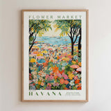 The image is a framed poster depicting a vibrant and colorful scene from the Havana Flower Market, with a variety of flowers, people, and umbrellas filling the frame.