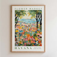 The image is a framed poster depicting a vibrant and colorful scene from the Havana Flower Market, with a variety of flowers, people, and umbrellas filling the frame.