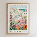 The image is a framed poster depicting a colorful and vibrant flower market in Santorini, Greece.