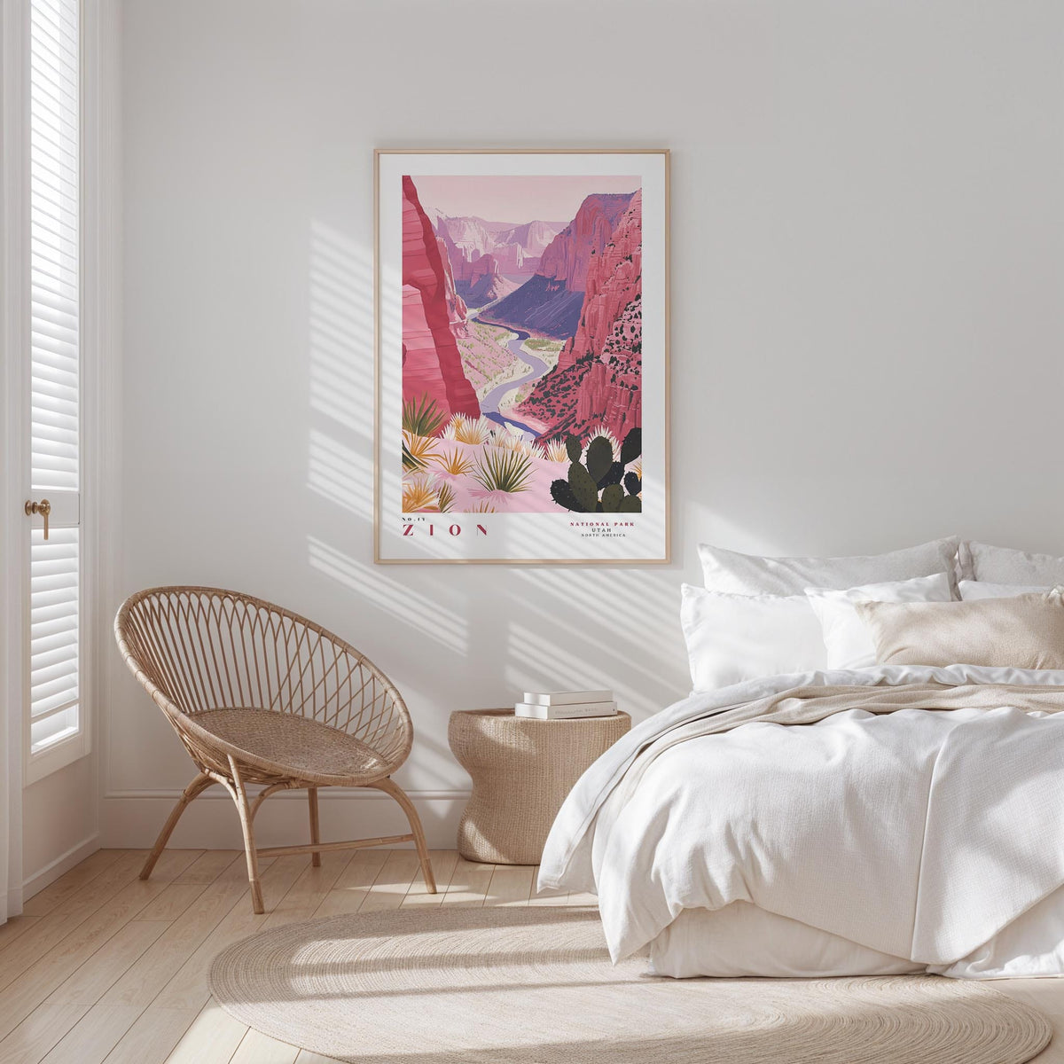 a bedroom with a large poster of a desert landscape hanging on the wall, featuring a canyon and mountains. The room has a white color scheme, with a bed, a woven chair, and a small side table.