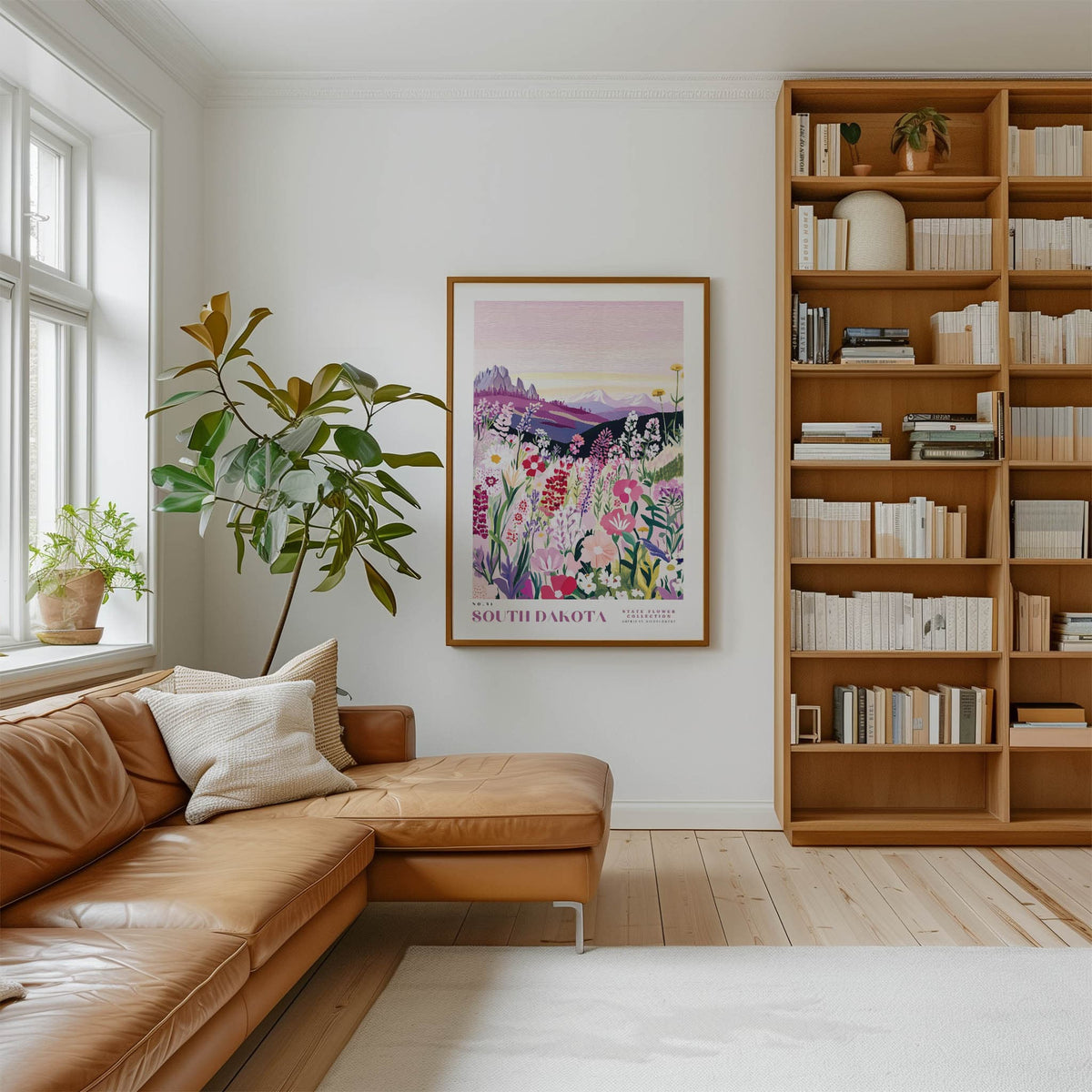 a cozy living room with a large bookshelf filled with books, a comfortable leather sofa, and a framed poster of a field of flowers hanging on the wall.