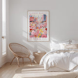a bedroom with a bed, a woven chair, and a framed poster of a flower market in Memphis, Tennessee.