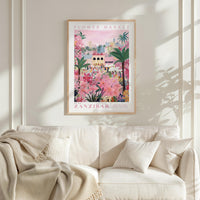 a poster of a flower market in Zanzibar hanging on a wall above a white couch with a blanket draped over it.