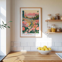 a framed poster of a colorful garden scene with a bridge in the background, hanging on a wall above a wooden countertop with a bowl of lemons.