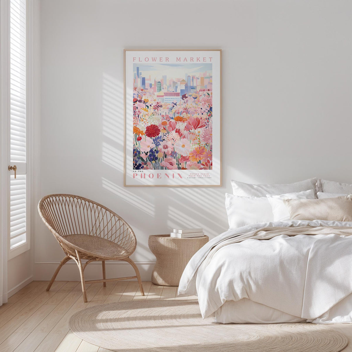 a bedroom with a bed, a woven chair, and a framed poster of a cityscape with flowers hanging on the wall.
