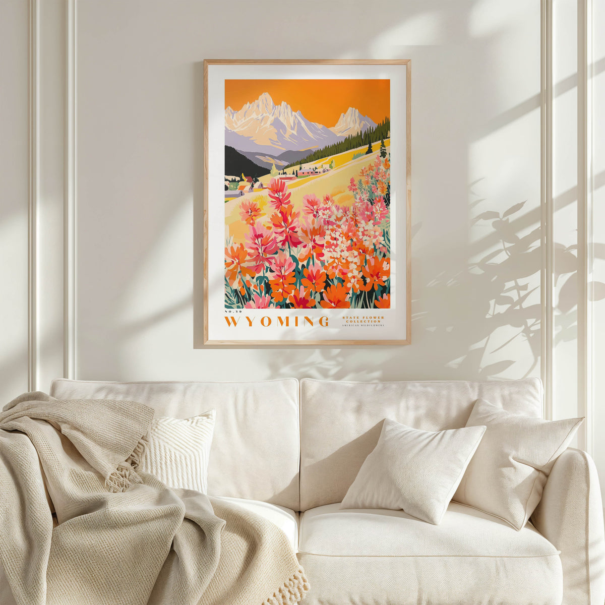 a framed poster of a scenic mountain landscape with a field of colorful flowers in the foreground.