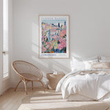 a bedroom with a large poster of a colorful floral scene hanging on the wall above a bed with white bedding.