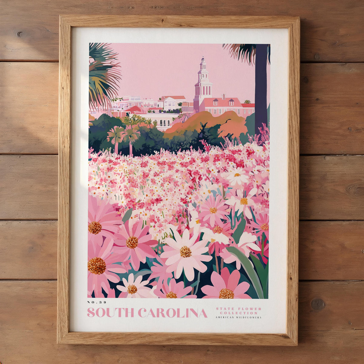 A framed poster depicting a vibrant field of pink and white flowers, with a tall tower in the background, likely representing the State Flower of South Carolina.