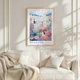 a cozy living room with a white sofa and a framed poster of a colorful floral scene hanging on the wall above it.