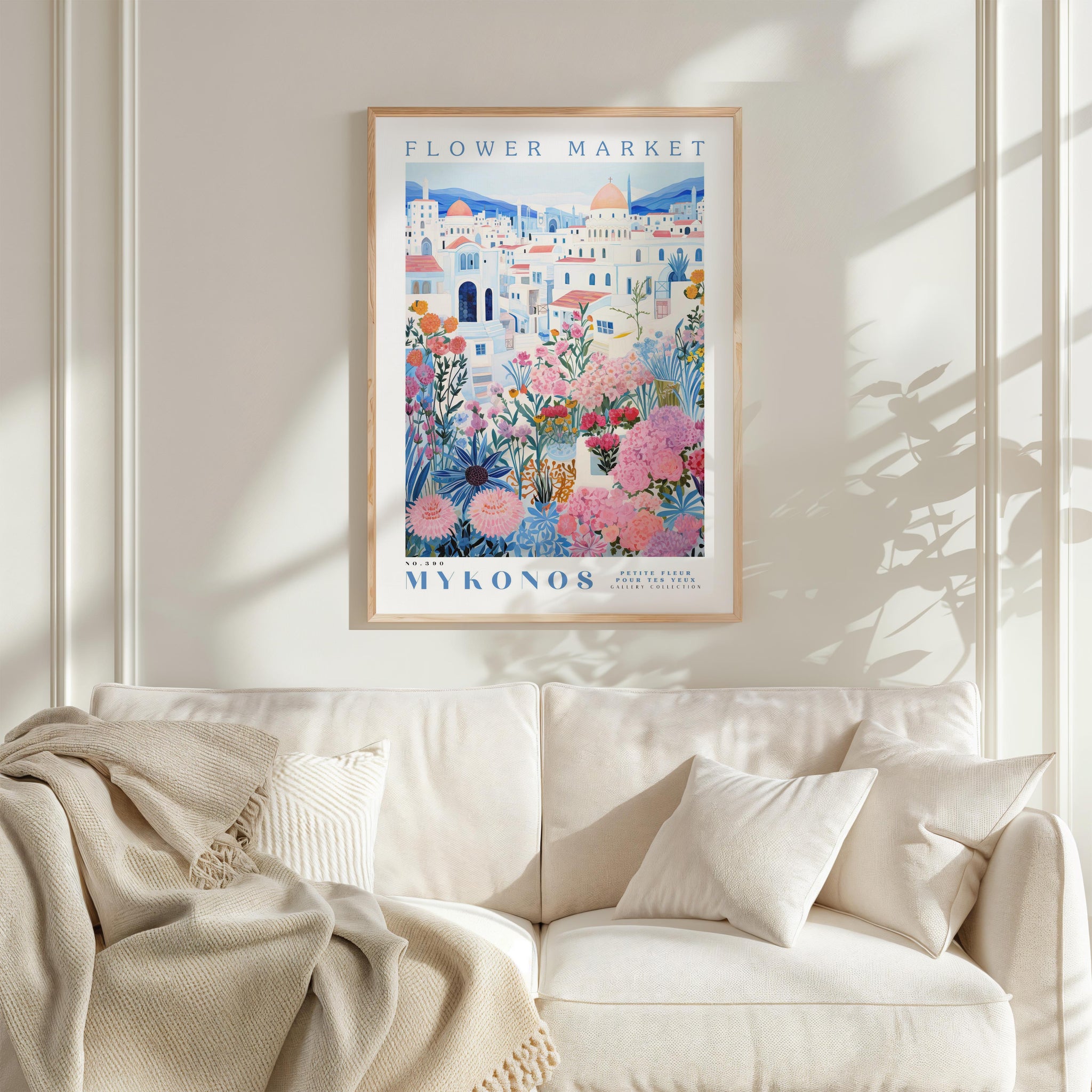 a cozy living room with a white sofa and a framed poster of a colorful floral scene hanging on the wall above it.