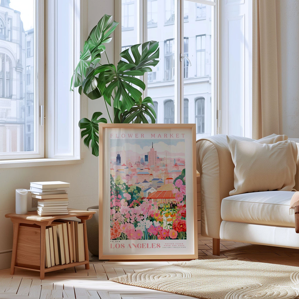 a framed poster of a cityscape with a flower market in the background, placed on a wooden floor in a living room with a white sofa and a bookshelf.