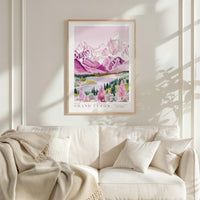 a framed poster of a scenic mountain landscape, hanging on a wall above a white couch with a blanket draped over it.