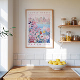 a kitchen counter with a bowl of lemons, a framed poster of a cityscape, and a shelf with jars and containers.
