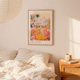 a bedroom with a bed, a nightstand, and a framed poster of a colorful floral scene hanging on the wall above the bed.