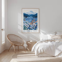 A bedroom with a large framed poster of a mountain landscape with flowers hanging on the wall, a woven chair, and a bed with white bedding.