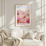 a framed poster of a flower market in Pittsburgh, Pennsylvania, hanging on a wall above a white couch with a blanket draped over it.