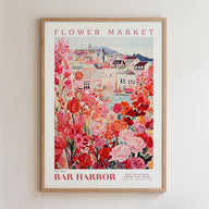 The image is a framed poster depicting a vibrant and colorful scene of a flower market in a town, with buildings, flowers, and a river in the background.