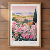 A framed poster depicting a scenic view of Iowa, with a colorful landscape featuring a town, mountains, and a field of flowers.